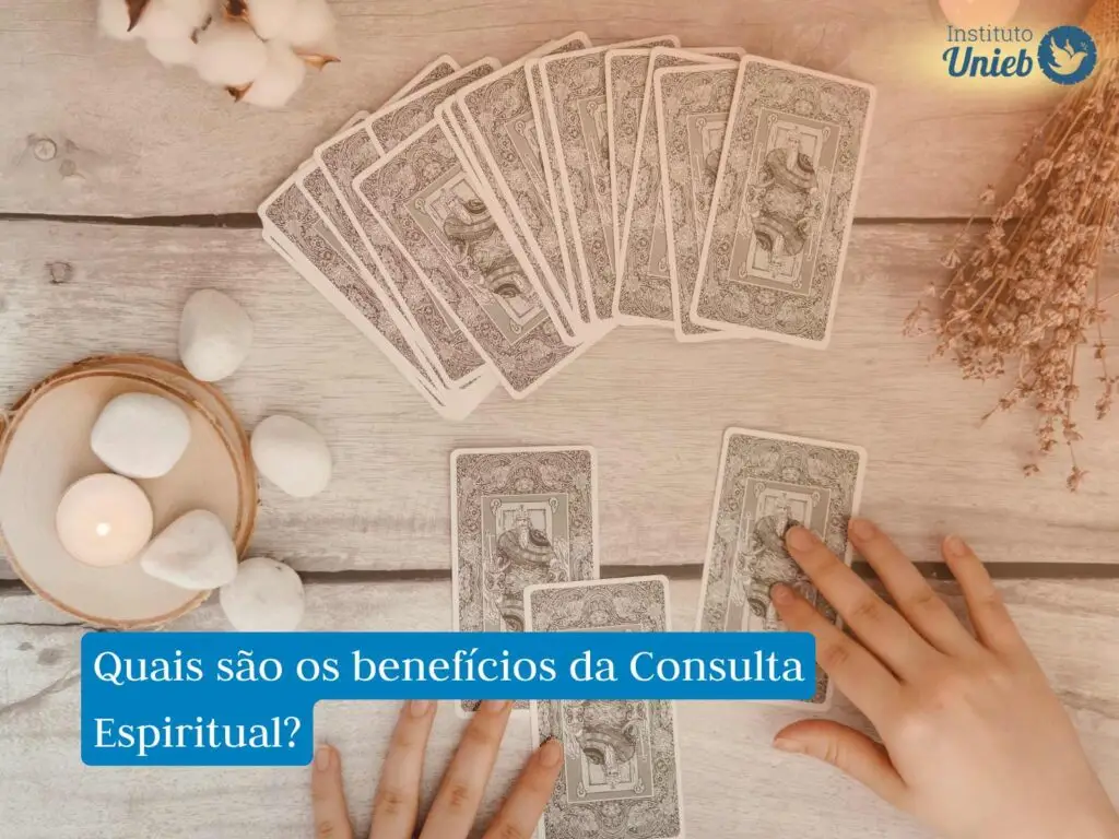 cartas de tarot dispostas na mesa junto com objetos como velas, pedras energéticas e ramos secos, simbolizando uma Consulta Espiritual, na parte superior à direita há um logo do Instituto Unieb e ao centro uma frase com fundo azul que diz "quais são os benefícios da Consulta Espiritual?"