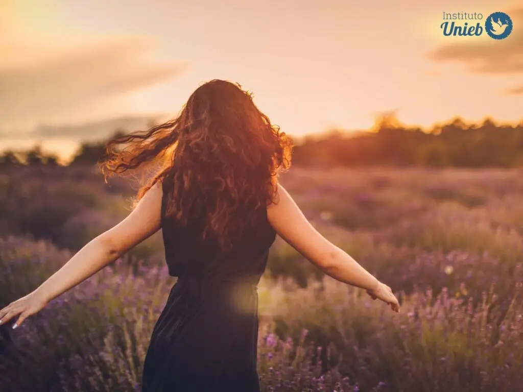 Mulher de vestido preto de costas em um campo com sol se pondo ao horizonte - Instituto Unieb (Pai de santo Roberson Dariel) - Contato 11 96982-1121 - CEP 14801-040 - Av. Dom Pedro II 562, Centro, Araraquara, SP