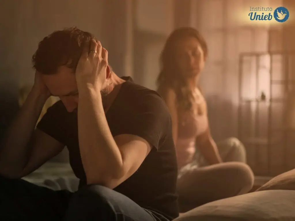 Homem com as mãos na orelha e mulher olhando com tristeza