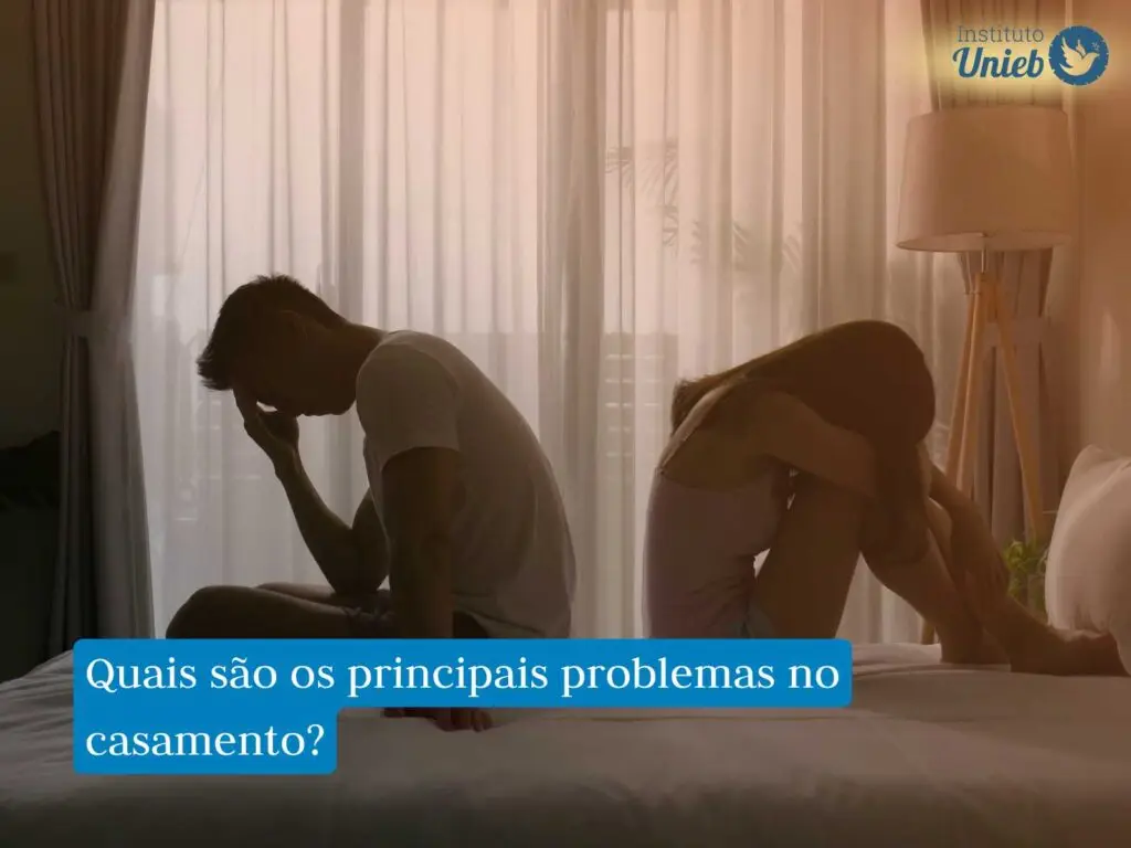 Homem e mulher sentados na cama de costas um para o outro