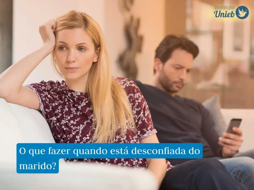 Mulher com a mão na cabeça de costas para homem ao fundo mexendo no celular