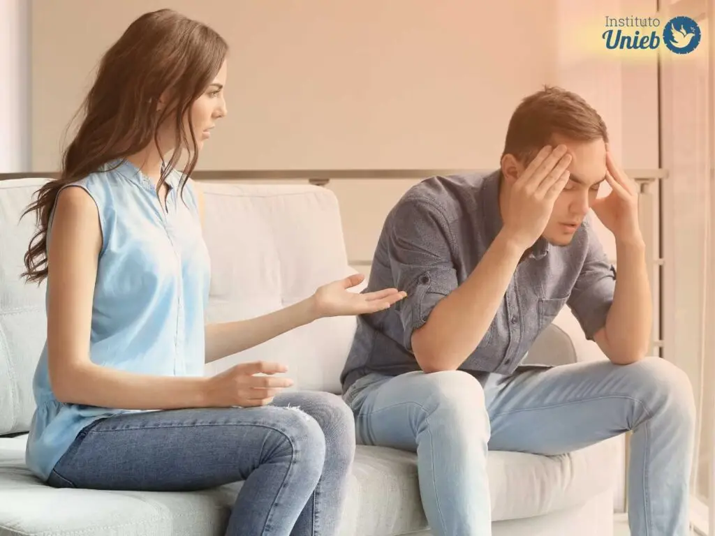 Homem e mulher sentados em sofá discutindo