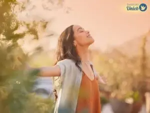 Mulher com os braços abertos e cabeça para cima de olhos fechados em meio a natureza - Instituto Unieb (Pai de santo Roberson Dariel) - Contato 11 96982-1121 - CEP 14801-040 - Av. Dom Pedro II 562, Centro, Araraquara, SP