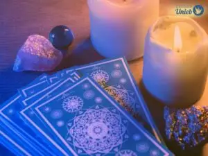Cartas de Tarot em cima de uma mesa com velas e outros elementos místicos - Instituto Unieb (Pai de santo Roberson Dariel) - Contato 11 96982-1121 - CEP 14801-040 - Av. Dom Pedro II 562, Centro, Araraquara, SP