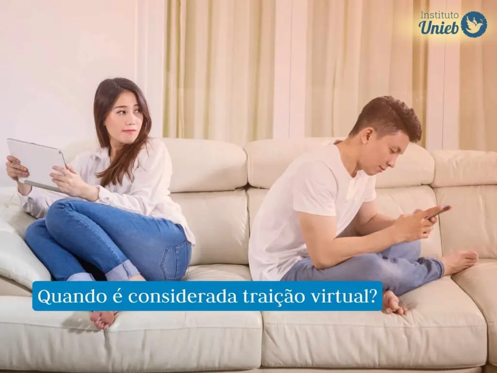 Casal de costas um para o outro sentados no sofá com dispositivos móveis nas mãos