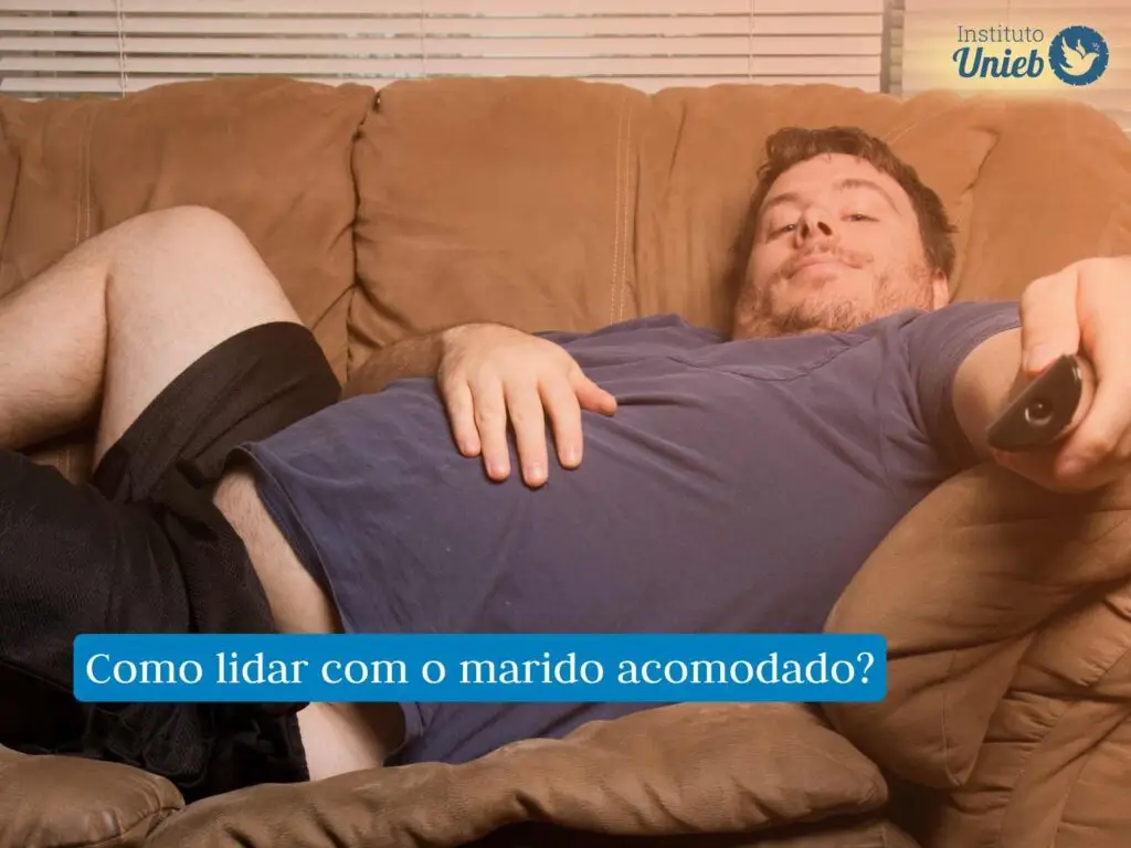 Homem vestindo camiseta azul e shorts preto deitado em sofá marrom