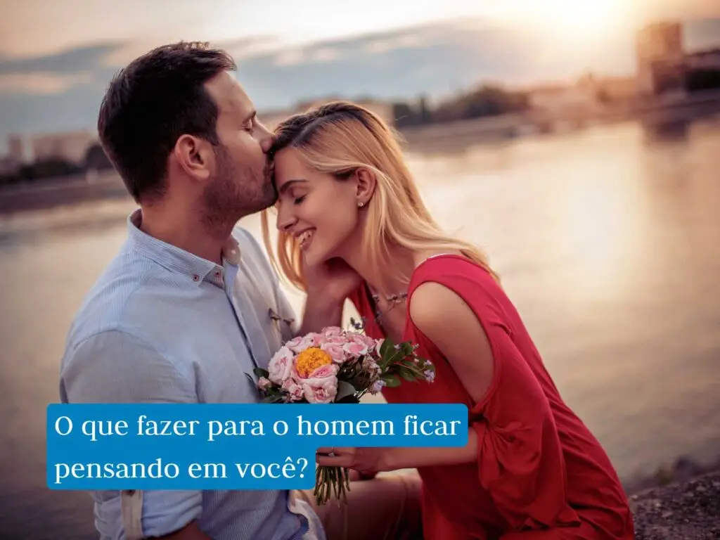Como deixar um homem pensando em você? Homem de cabelo preto e camisa azul claro beijando a testa de uma mulher loira com vestido vermelho segurando um buquê de flores coloridas ao ar livre