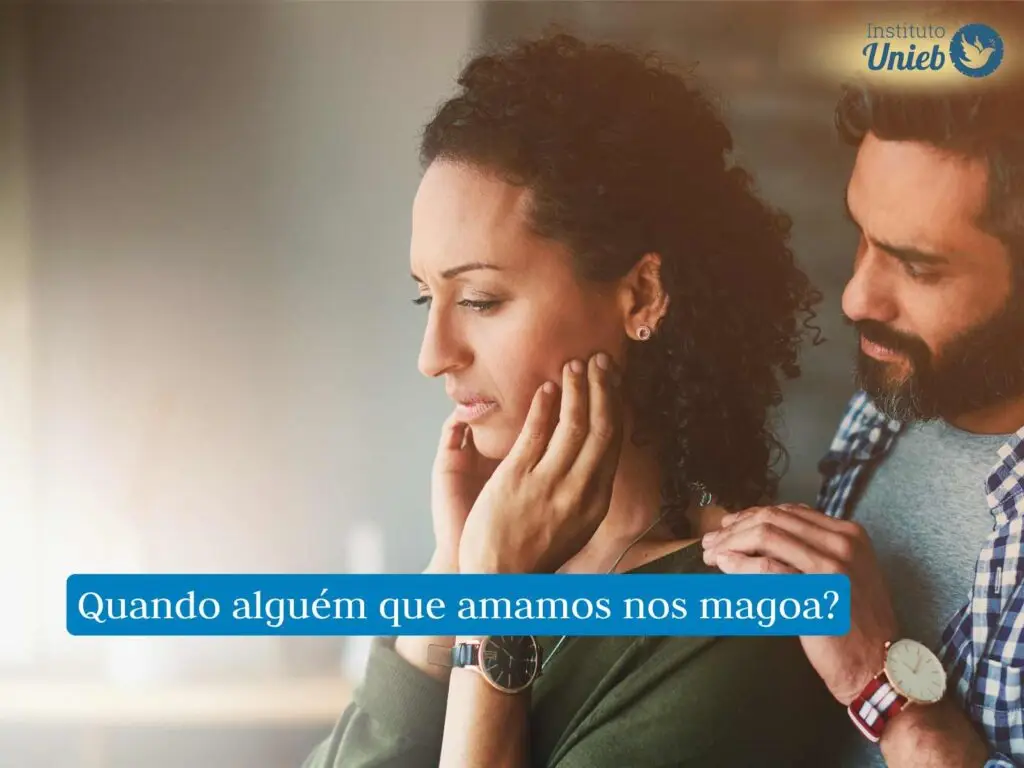 Mulher com mãos no rosto e expressão chateada, enquanto homem segura seu ombro tentando se desculpar