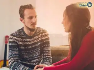 Homem e mulher sentados de frente um para o outro em uma conversa difícil