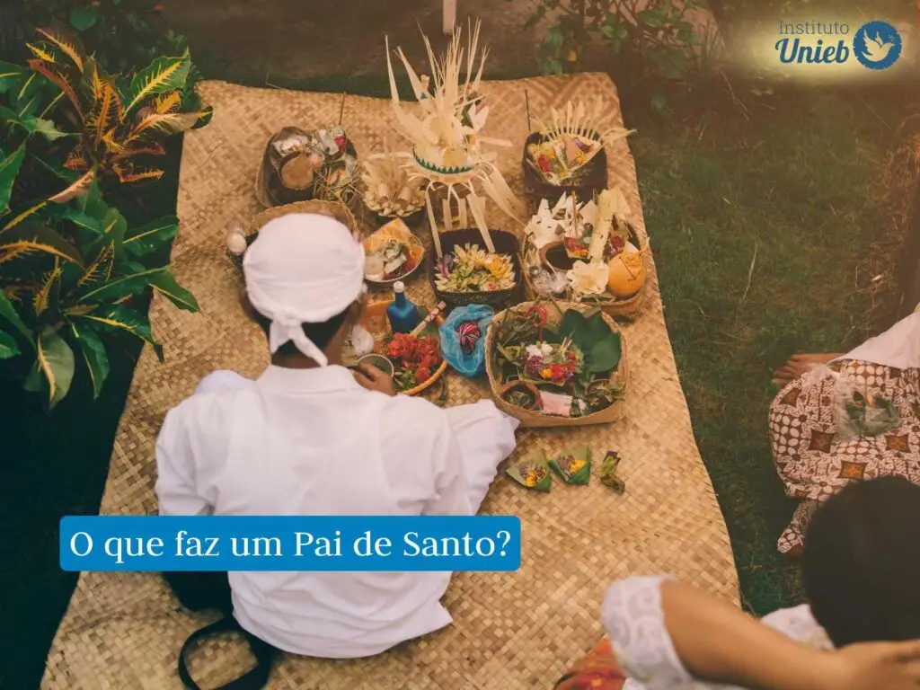 Homem com vestes brancas da religião afro-brasileira Umbanda em cima de tapete de palha preparando uma oferenda religiosa