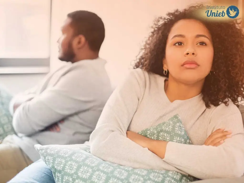 Homem e mulher sentados de costas no sofá da sala