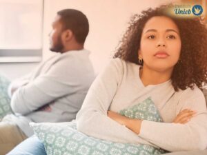 Homem e mulher sentados de costas no sofá da sala