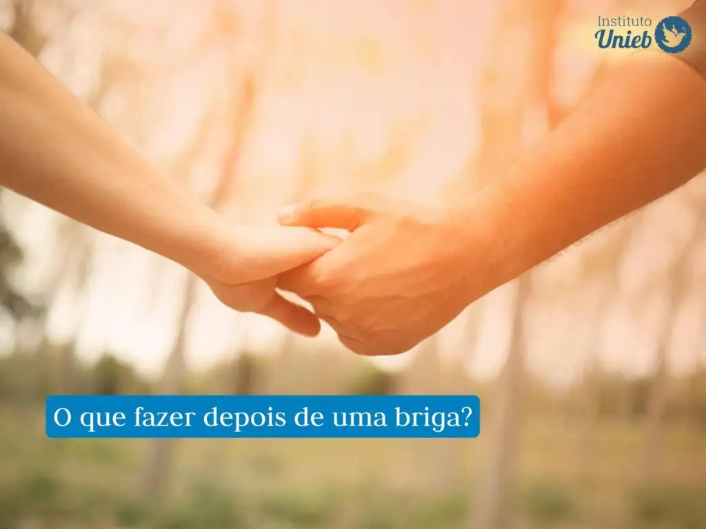 Duas mãos se segurando em um ambiente aberto