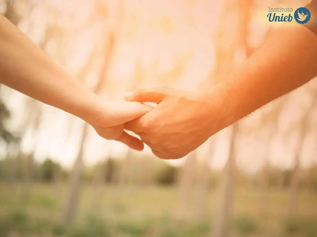 Duas mãos se segurando em um ambiente aberto