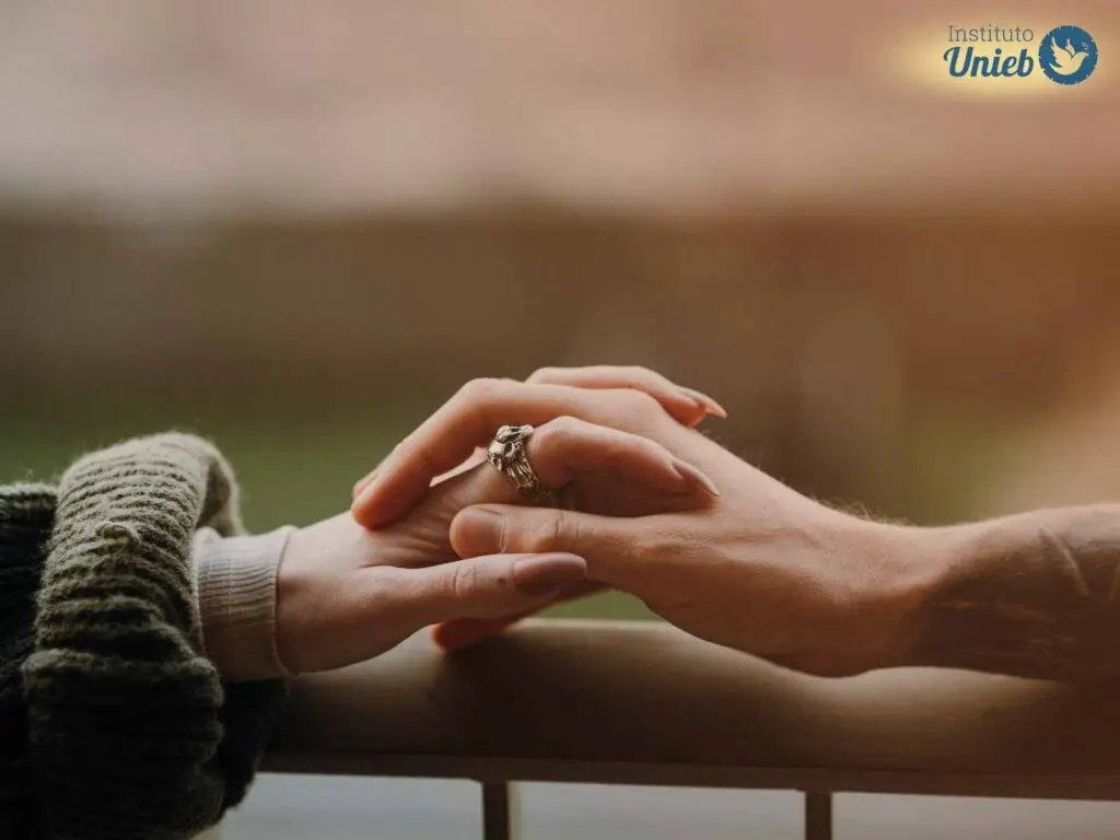 Mão feminina e masculina entrelaçada