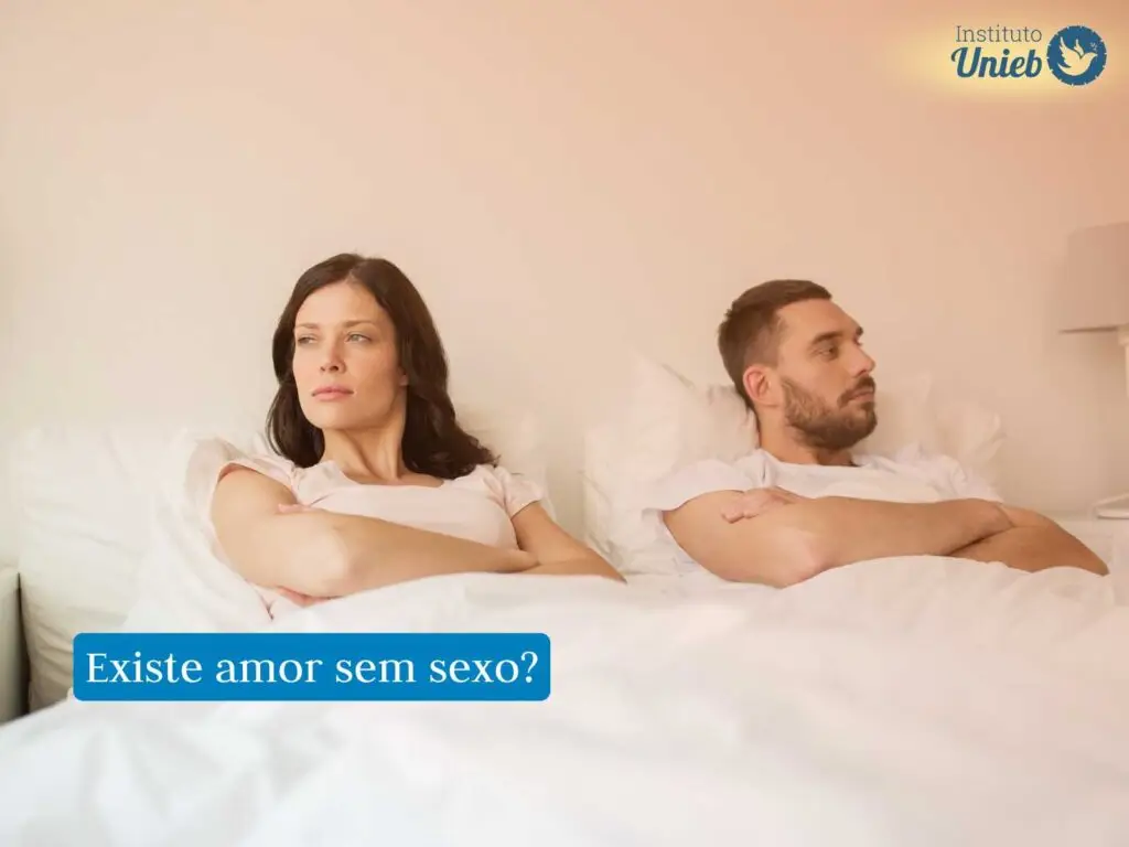 Casal deixado na cama de braços cruzados e expressão de frustração