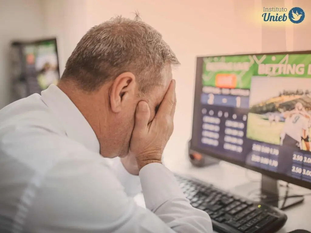 Homem com as mãos no rosto em frente a um computador onde a tela mostra um site de apostas - Instituto Unieb (Pai de santo Roberson Dariel) - Contato 11 96982-1121 - CEP 14801-040 - Av. Dom Pedro II 562, Centro, Araraquara, SP