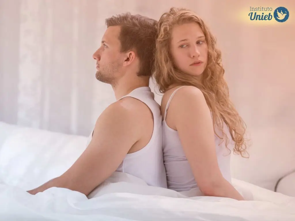 Homem e mulher sentados de costas um para o outro