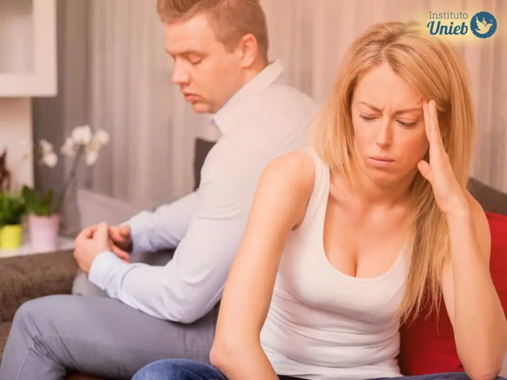 Homem e mulher sentados de costa um para o outro com expressão de frustração