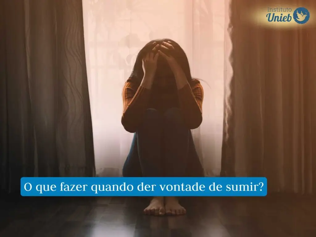 Mulher sentada no chão do quarto com as mãos na cabeça