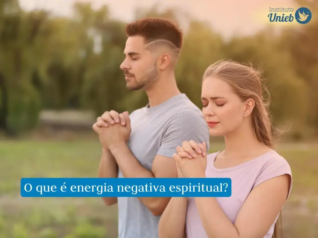 Homem e mulher em ambiente externo com mãos em prece e olhos fechados enquanto rezam