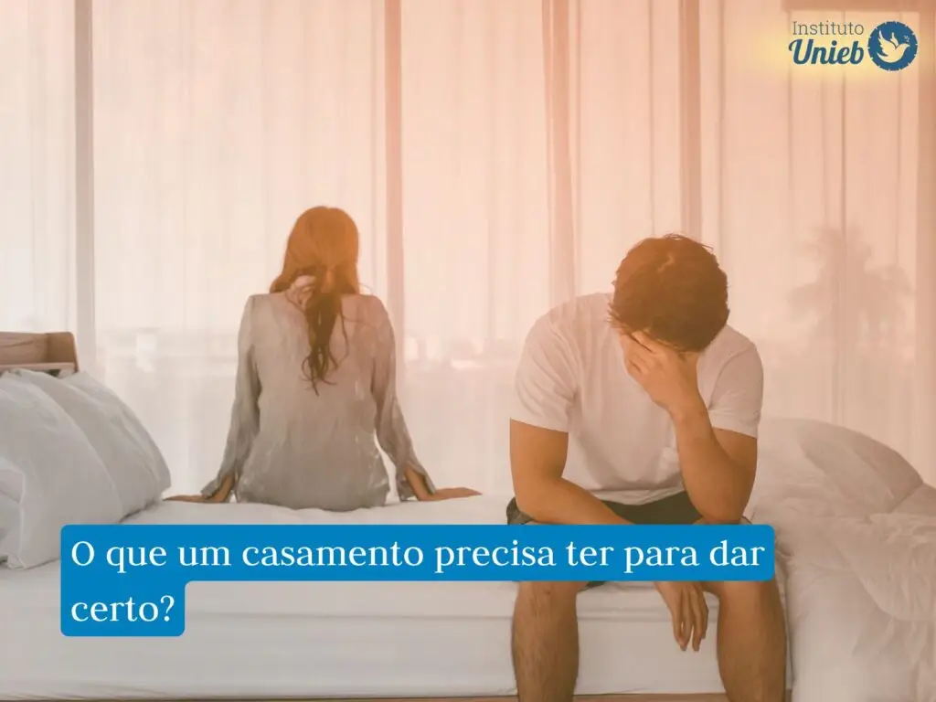 Homem e mulher sentados na cama de costas um para o outro