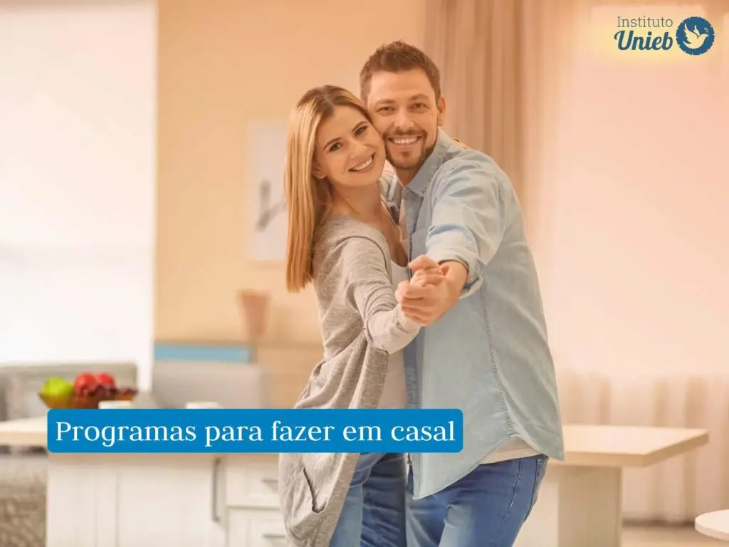 Homem e mulher abraçados e de mãos dadas dançando dentro da casa
