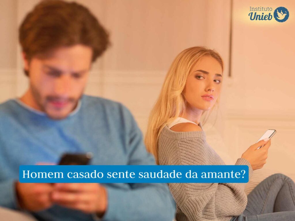 Homem que tem amante ama a esposa? Homem sentado no sofá olhando para celular e mulher ao fundo com celular na mão olhando para seu marido desconfiada e triste