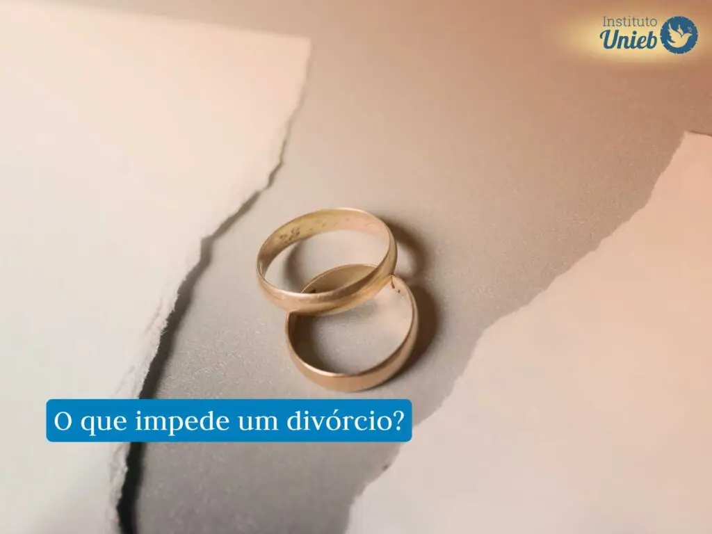 Duas alianças sob uma mesa com um papel branco cortado ao meio