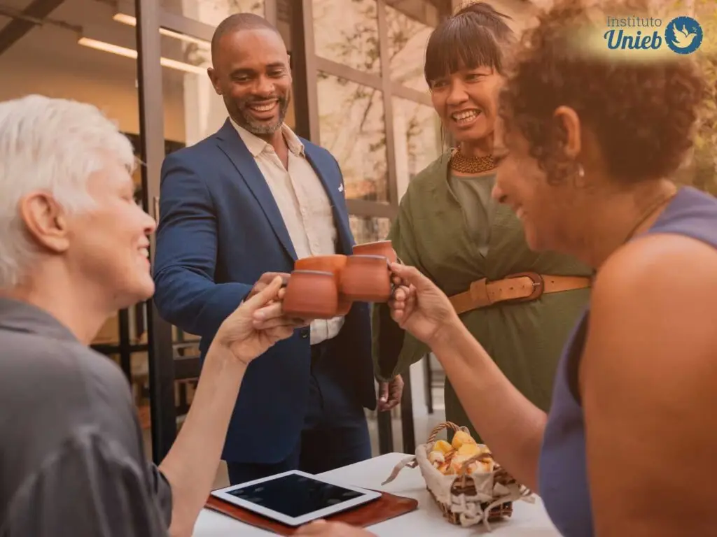 Grupo de amigos brindando com xícaras de barro em um ambiente aberto