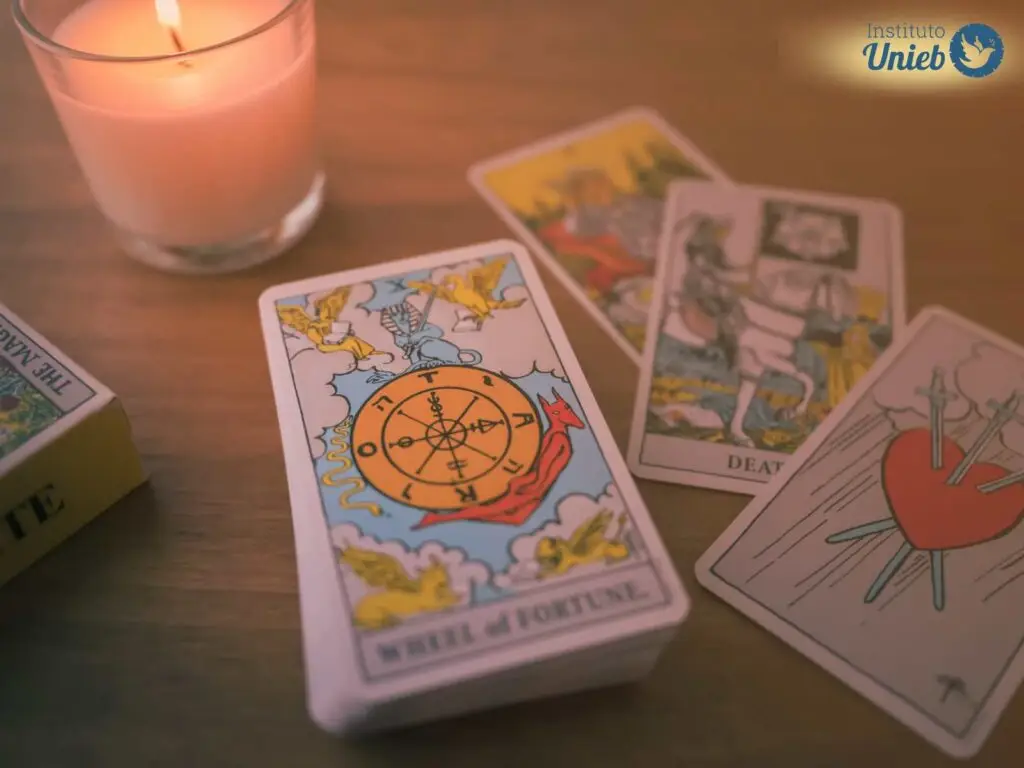 Cartas de tarot sobre uma mesa de madeira com vela acesa - Instituto Unieb (Pai de santo Roberson Dariel) - Contato 11 96982-1121 - CEP 14801-040 - Av. Dom Pedro II 562, Centro, Araraquara, SP