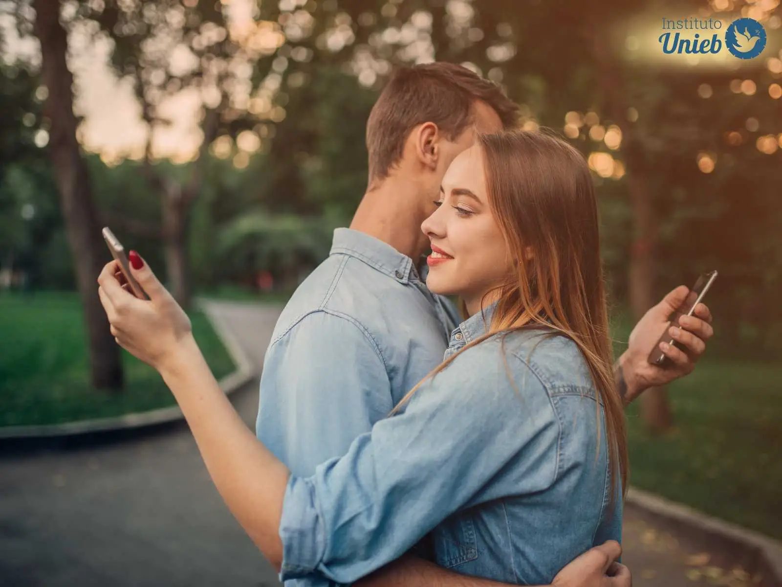 Homem e mulher abraçados cada um com um celular na mão