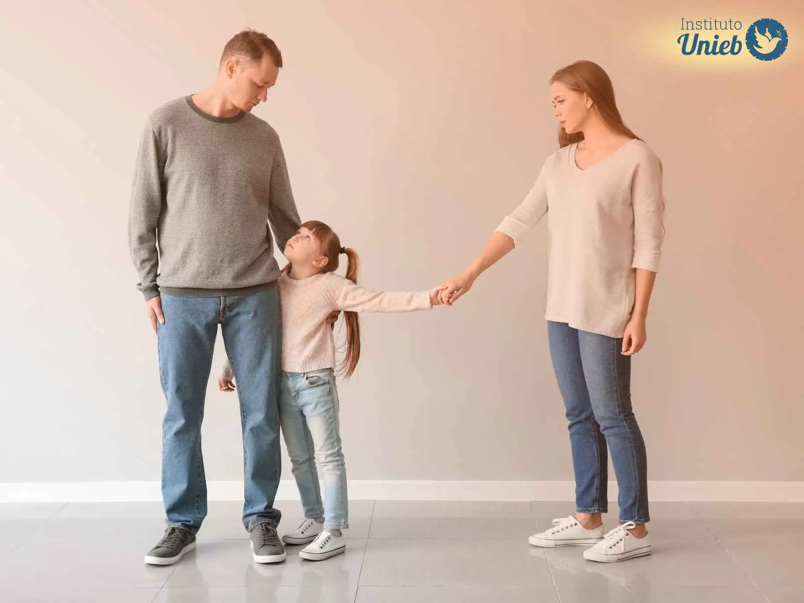 Homem, mulher e filha entre o casal divorciado segurando a mão da mãe e a perna do pai