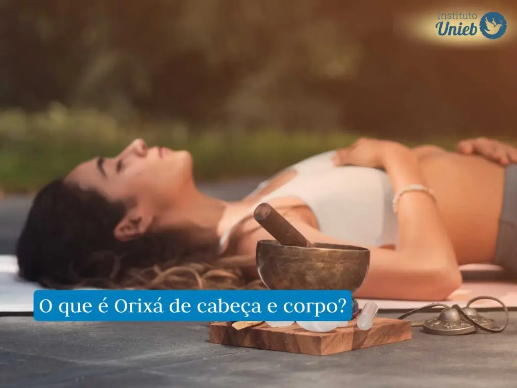 Mulher com top branco deitada no chão com braço em cima do peite e olhos fechados com defumador próximo à câmera e outros elementos de meditação