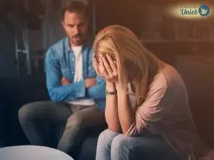 Homem e mulher sentados em sofá em meio a uma discussão de relacionamento