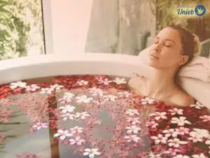 Mulher dentro de banheira com água e flores em tons de rosa e vermelho - Instituto Unieb (Pai de santo Roberson Dariel) - Contato 11 96982-1121 - CEP 14801-040 - Av. Dom Pedro II 562, Centro, Araraquara, SP