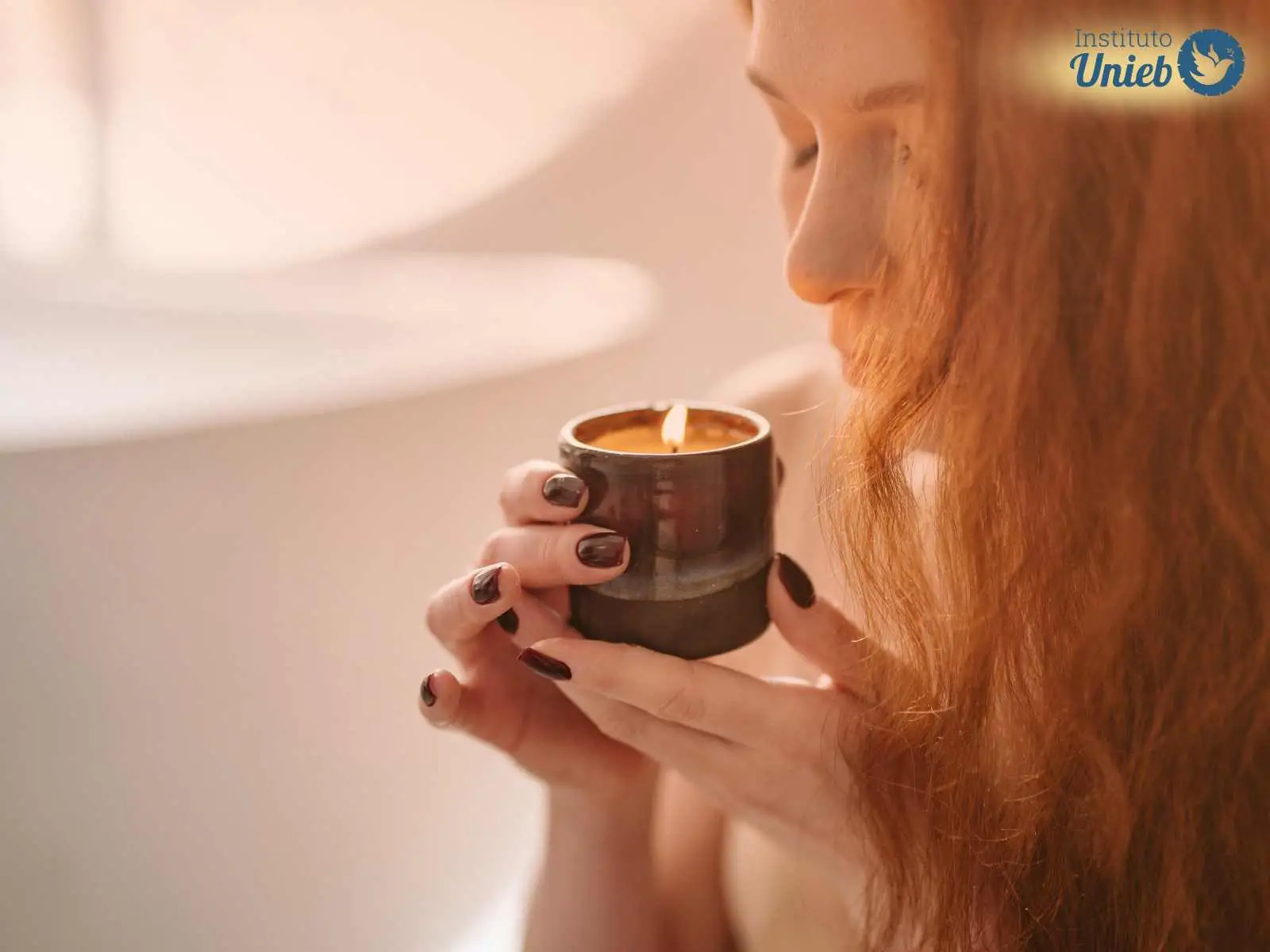 Mulher com cabelos soltos cobrindo parte do rosto segurando com as duas mãos um pote escuro com uma vela acesa - Instituto Unieb (Pai de santo Roberson Dariel) - Contato 11 96982-1121 - CEP 14801-040 - Av. Dom Pedro II 562, Centro, Araraquara, SP