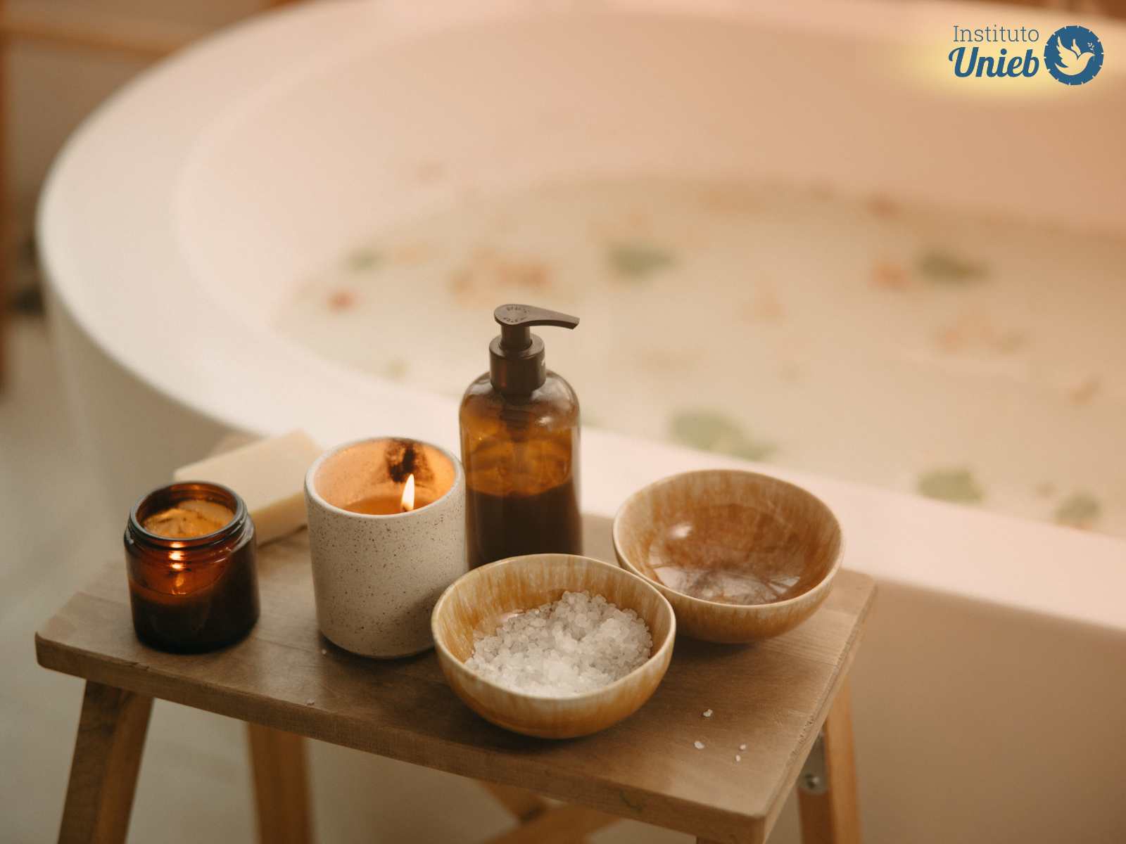Banheira com água e ervas com mesinha de madeira ao lado com velas acesas, frasco de sabonete líquido e potes com sal grosso - Instituto Unieb (Pai de santo Roberson Dariel) - Contato 11 96982-1121 - CEP 14801-040 - Av. Dom Pedro II 562, Centro, Araraquara, SP