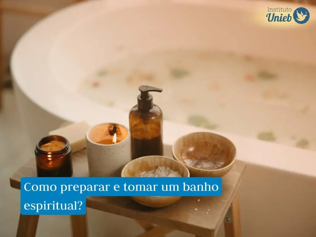 Banheira com água e ervas com mesinha de madeira ao lado com velas acesas, frasco de sabonete líquido e potes com sal grosso