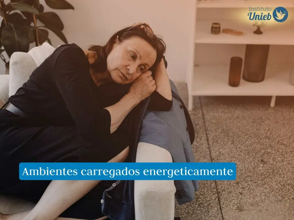 Mulher de meia-idade deitada no sofá com a cabeça apoiada nos braços com expressão triste no rosto