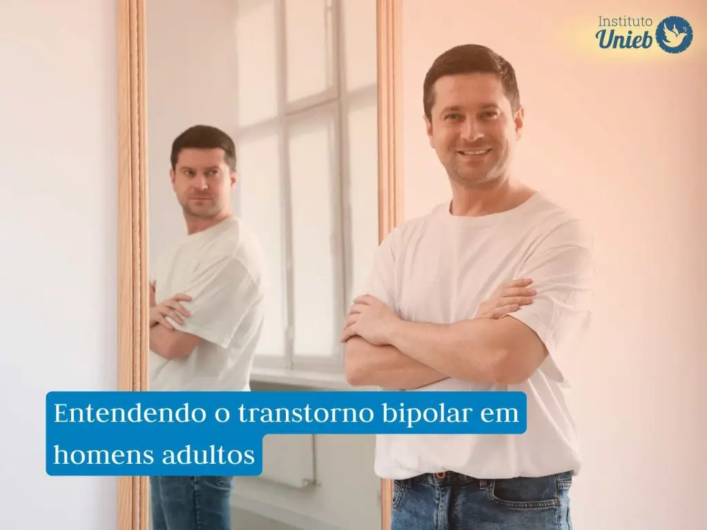 Homem vestindo camiseta branca e jeans com braços cruzados olhando para câmera sorrindo com espelho ao fundo refletindo sua imagem com expressão de raiva