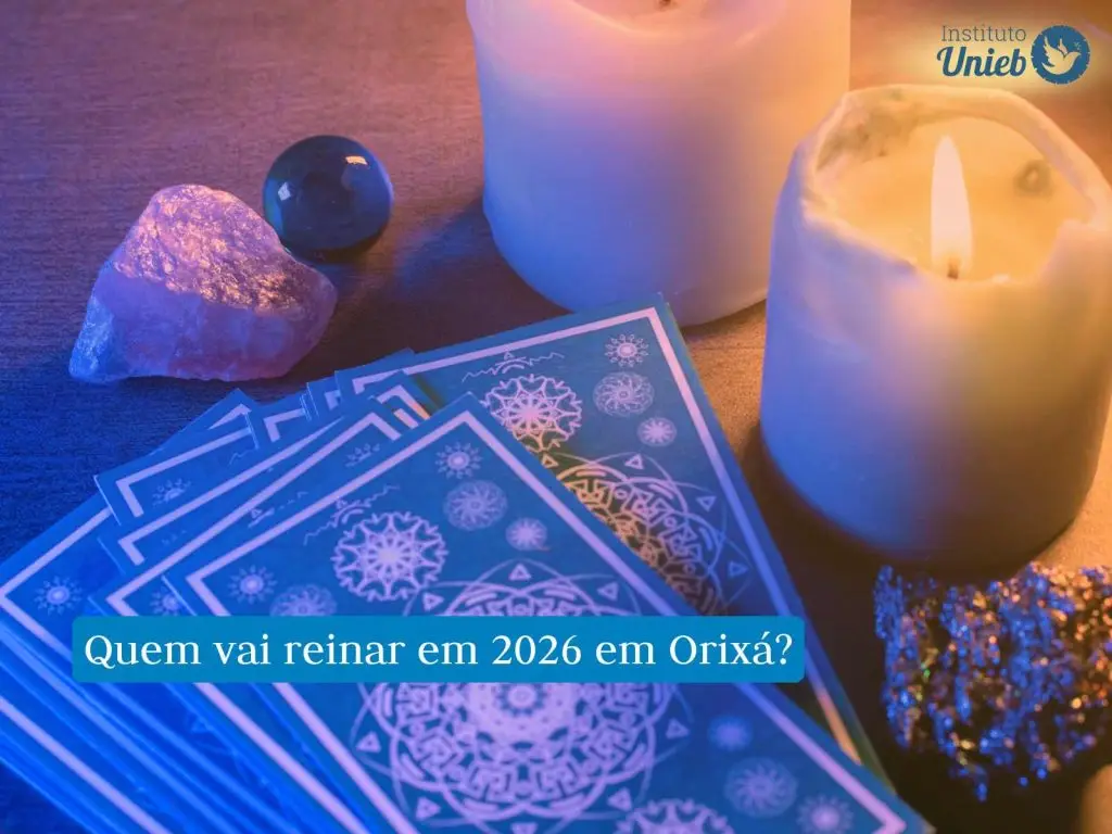 Cartas de Tarot sob a mesa de madeira ao lado de duas velas acesas e cristais energéticos