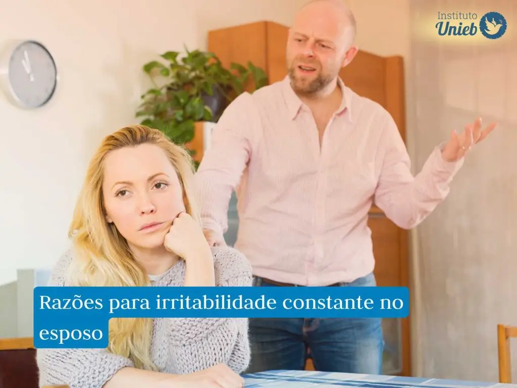 Homem gesticulando irritado e de mau humor atrás da mulher que está sentada com rosto apoiado na mão