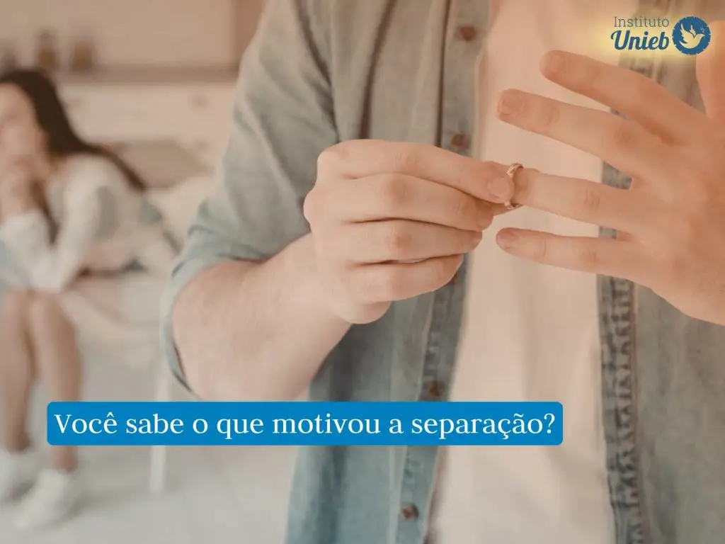 Homem vestindo camisa jeans azul claro e camiseta branca tirando aliança do dedo e ao fundo uma mulher lamentando