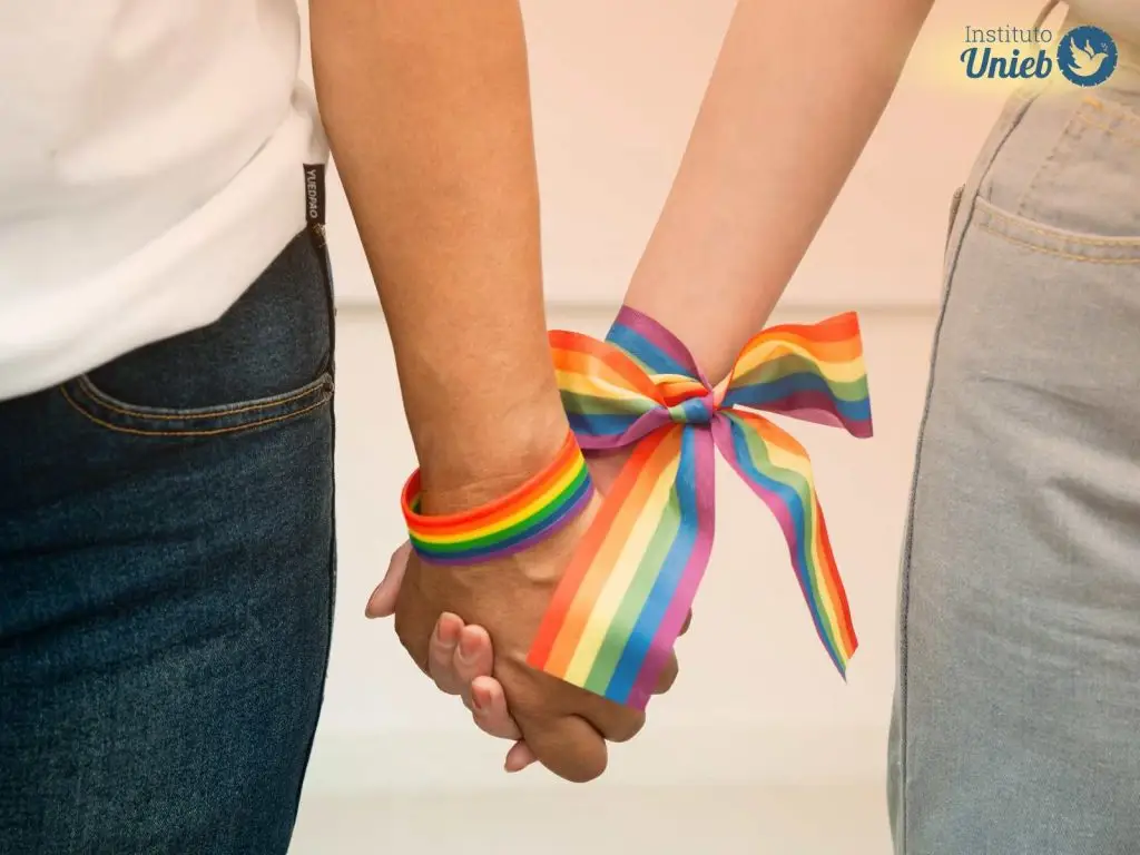 Duas pessoas segurando as mãos com um laço em cor de arco-íris amarrando as mãos - Instituto Unieb (Pai de santo Roberson Dariel) - Contato 11 96982-1121 - CEP 14801-040 - Av. Dom Pedro II 562, Centro, Araraquara, SP