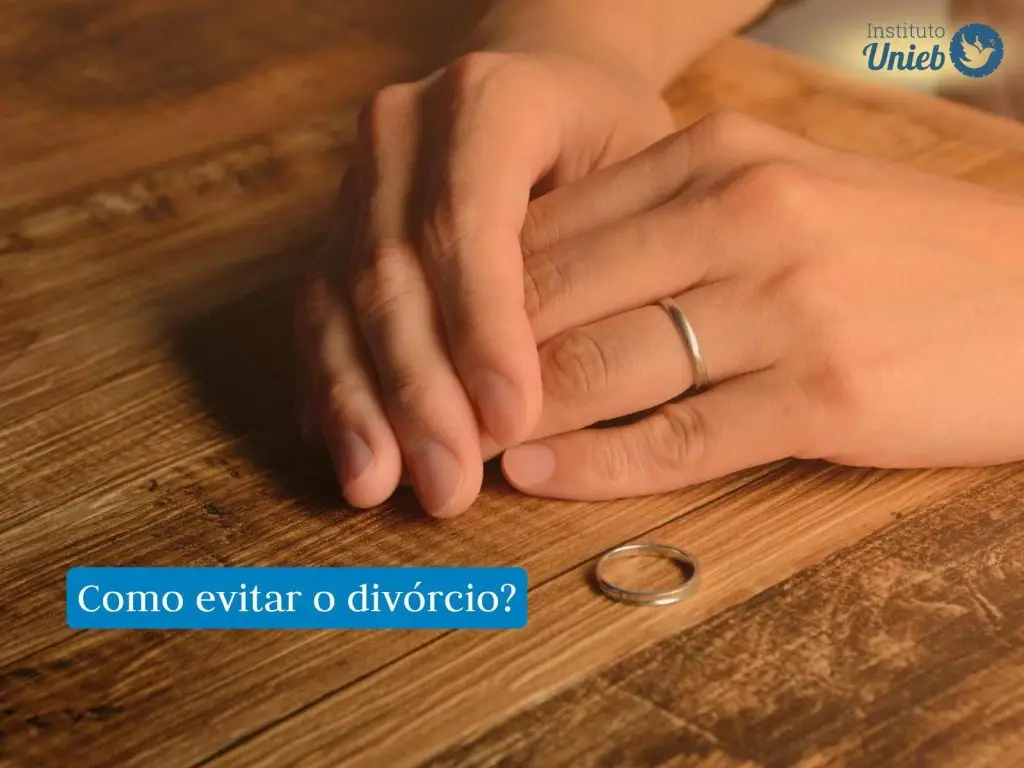 Mãos uma sob a outra em uma mesa de madeira com uma aliança sob a mesa