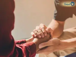 Mãos de um homem segurando as mãos de uma mulher como forma de reconquistar a ex-esposa depois da separação