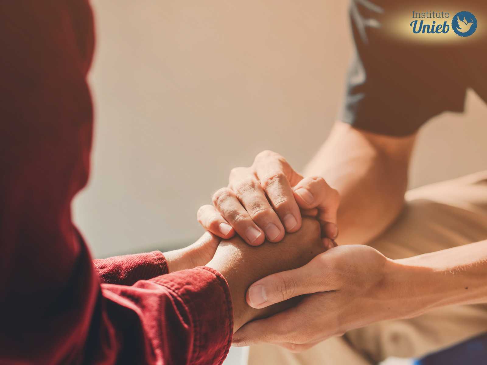 Mãos de um homem segurando as mãos de uma mulher como forma de reconquistar a ex-esposa depois da separação