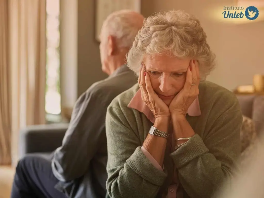 Casal de idosos sentados um de costas para o outro indicando um estado de tristeza e depressão no casamento