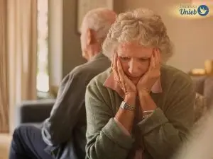 Casal de idosos sentados um de costas para o outro indicando um estado de tristeza e depressão no casamento